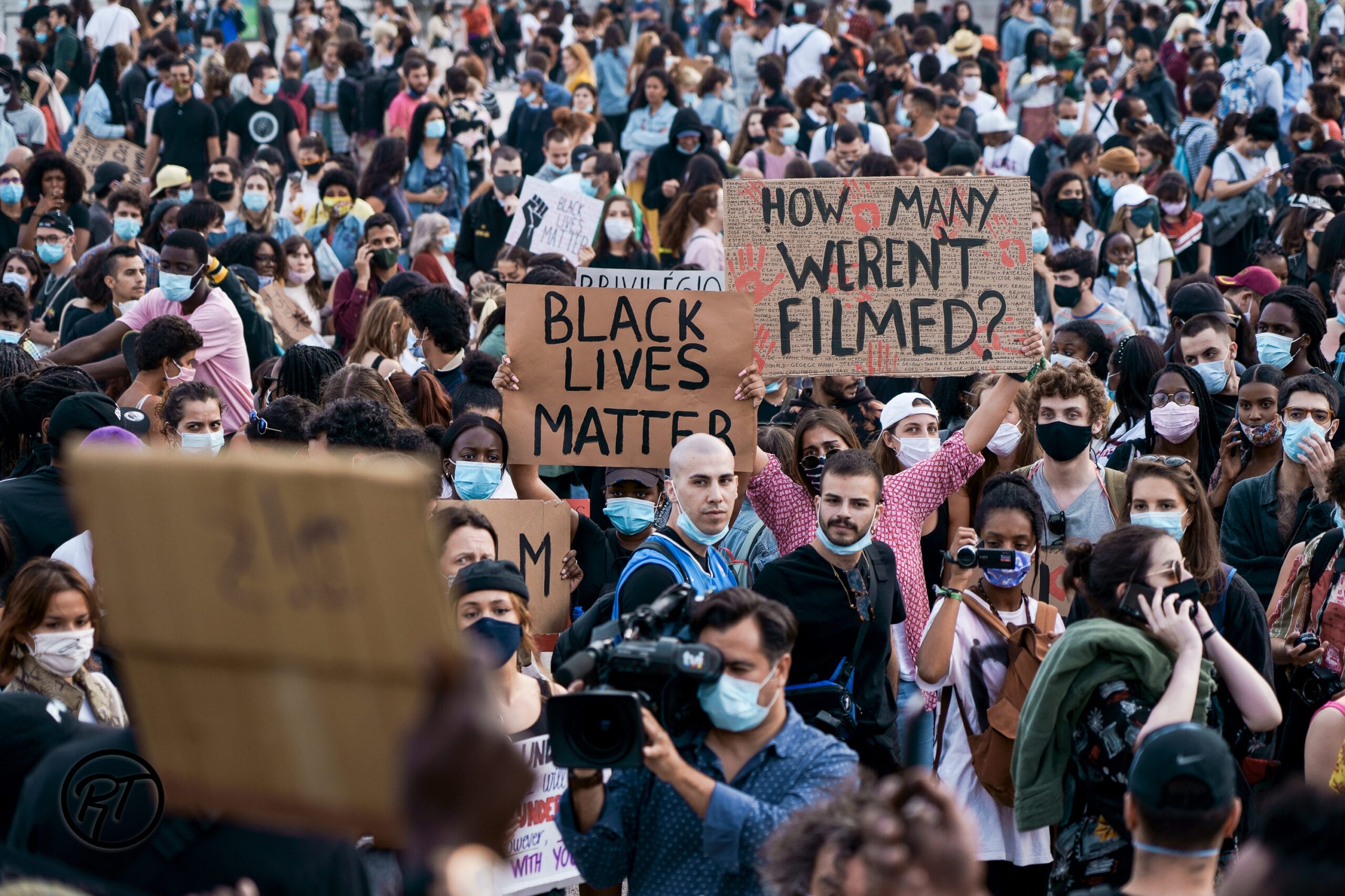 Reportagem de pessoas segurando cartazes durante manifestação