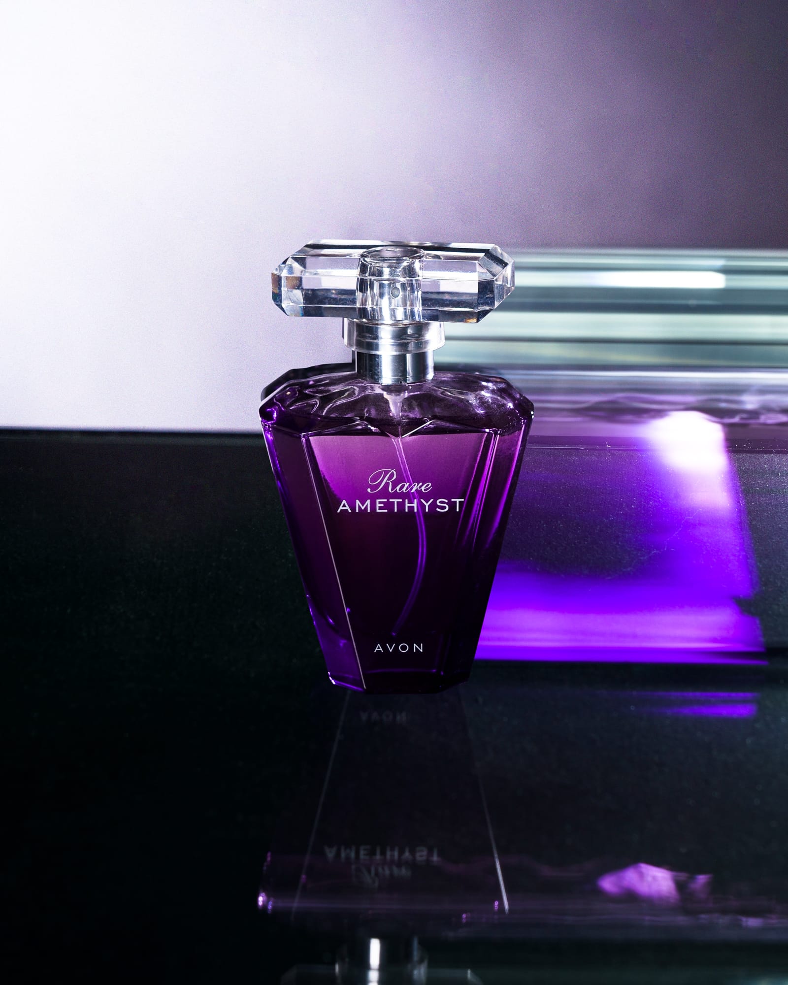 Frasco de perfume em composição publicitária com luz roxa